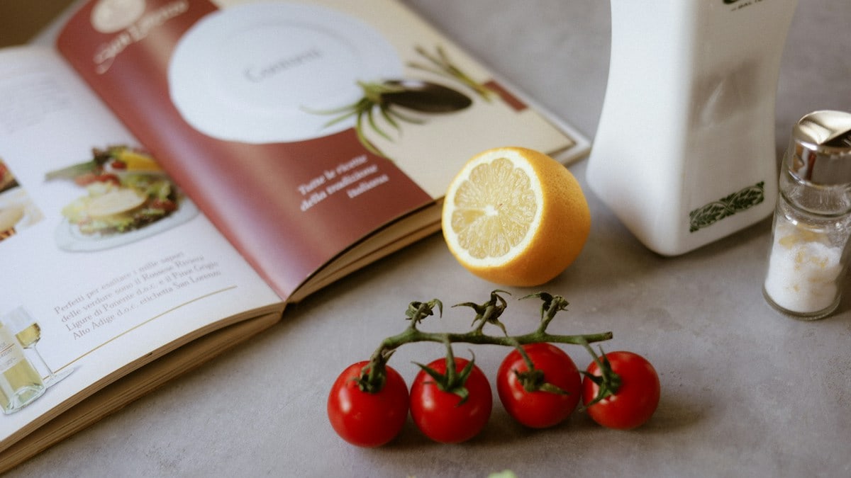 A table topped with a plate of food and a book